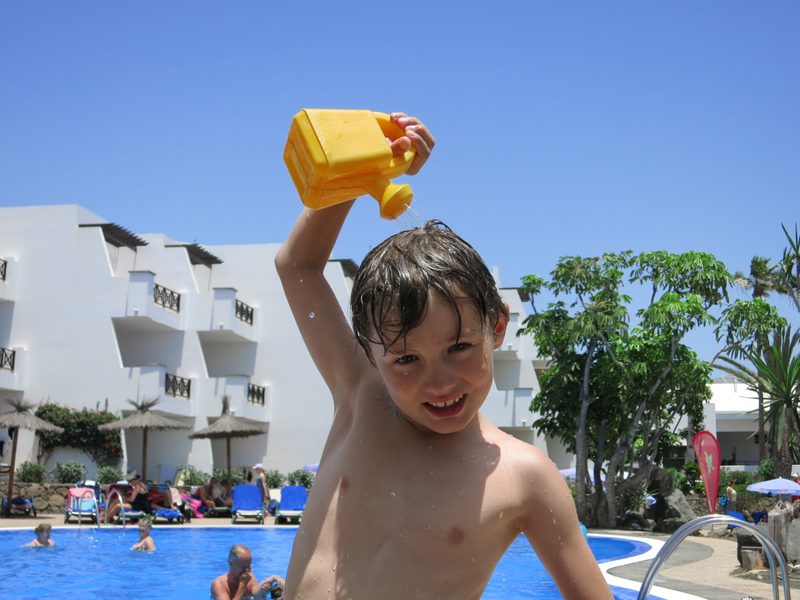 Merlin am Pool mit einem gelben Spielzeug